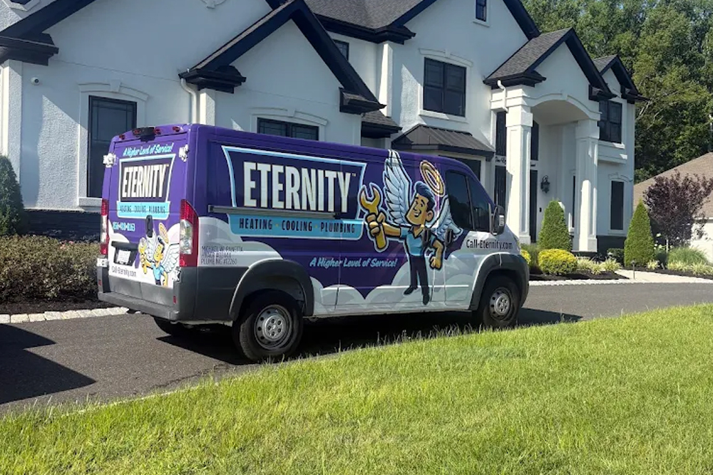 Eternity Heating and Cooling van parked outside a modern white house on a sunny day.