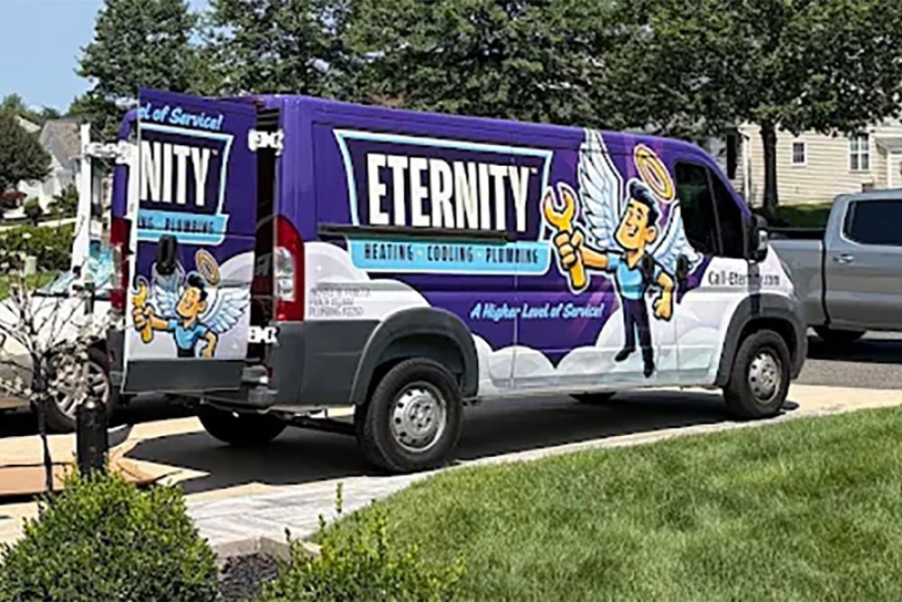 Eternity heating, cooling, plumbing van parked in suburban neighborhood driveway, featuring winged cartoon mascot.