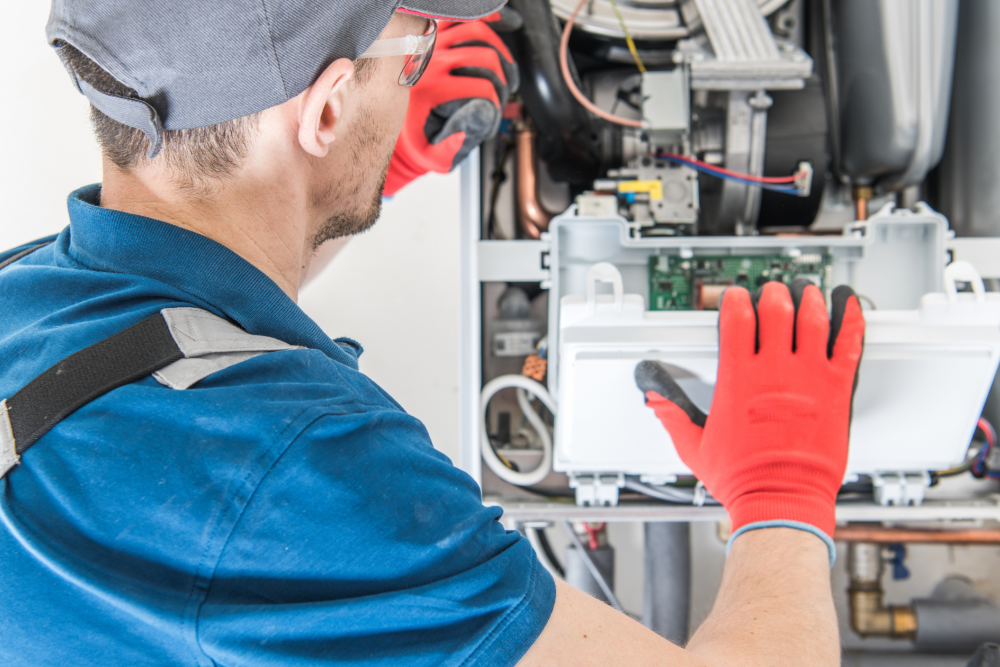 Technician in red gloves repairing a home heating system, ensuring optimal performance and safety.